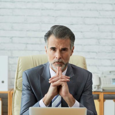 chief-executive-officer-working-laptop-with-determined-look-camera (1)